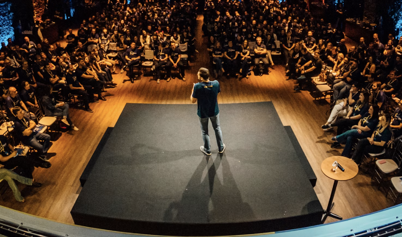 Speaker on stage above a large seated audience